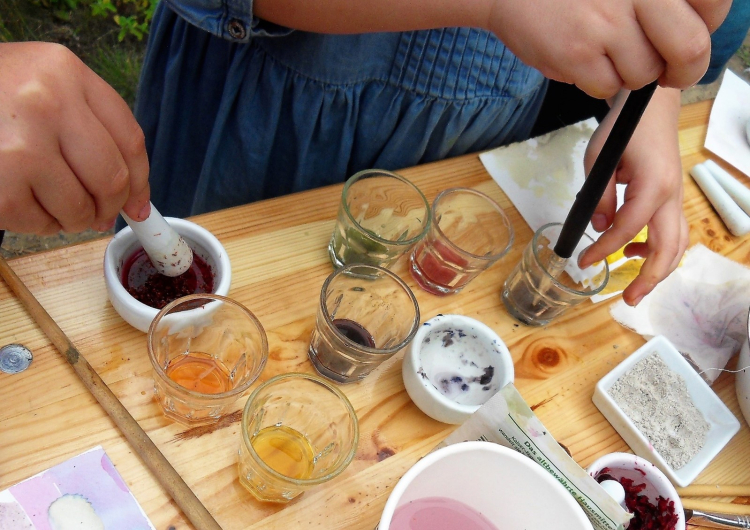Hände und Gefäße mit Färberpflanzen