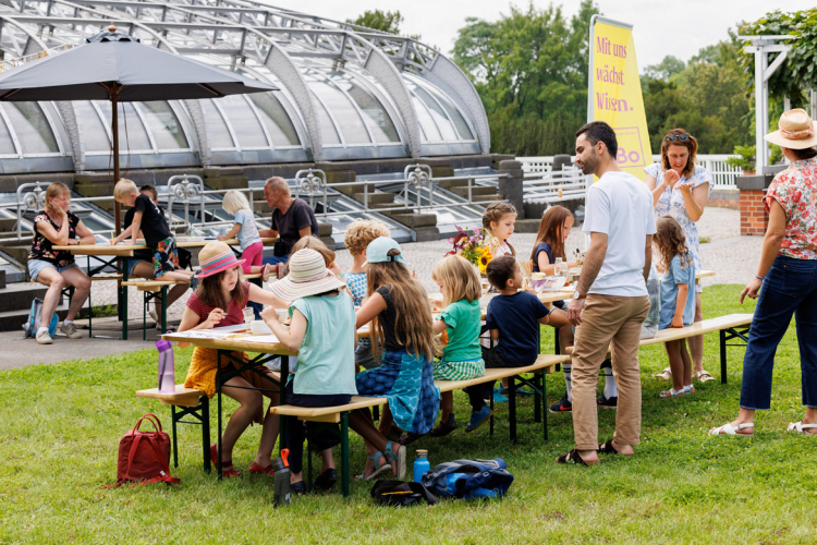 Menschen an Tischen im Garten färben mit Pflanzenfarbe