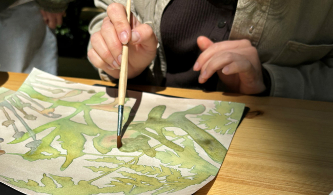 <p>Blatt Papier mit gemalten Pflanzen und Hand mit Pinsel</p>