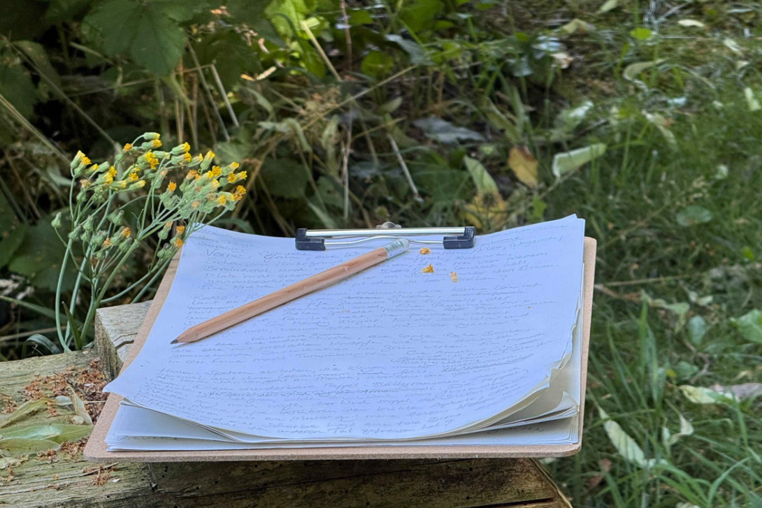 <p>Klemmbrett mit Handschrift im Grünen</p>